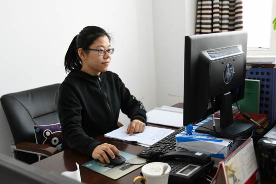 桌子上放着笔记本电脑前的人中度可信度描述已自动生成